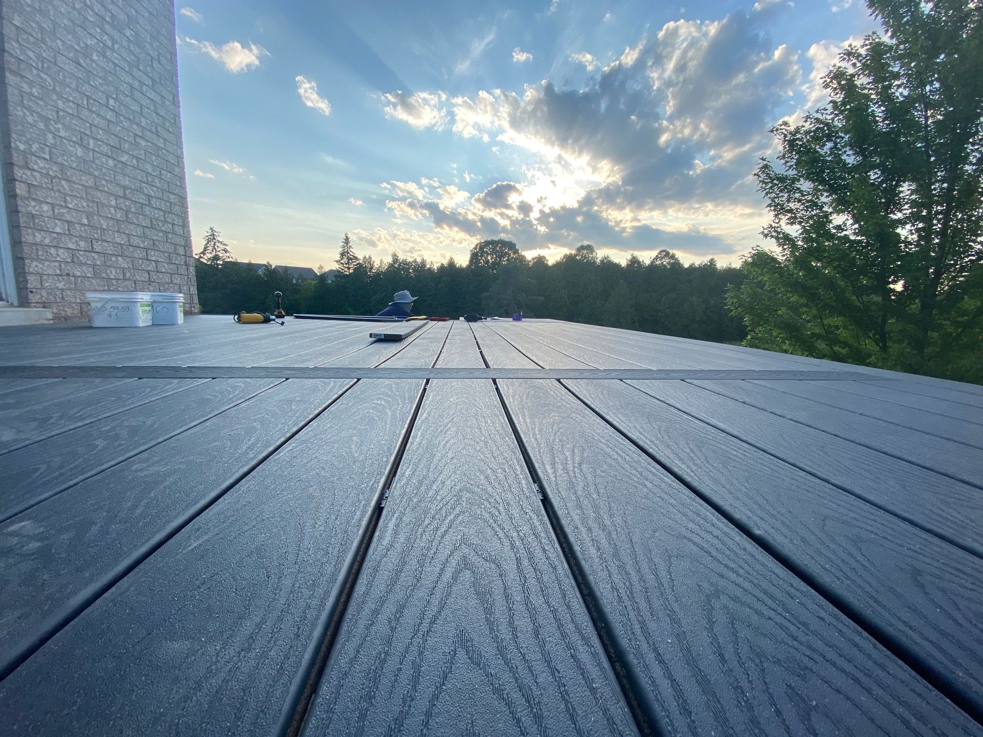 A wooden deck with trees in the background and a building in the background.