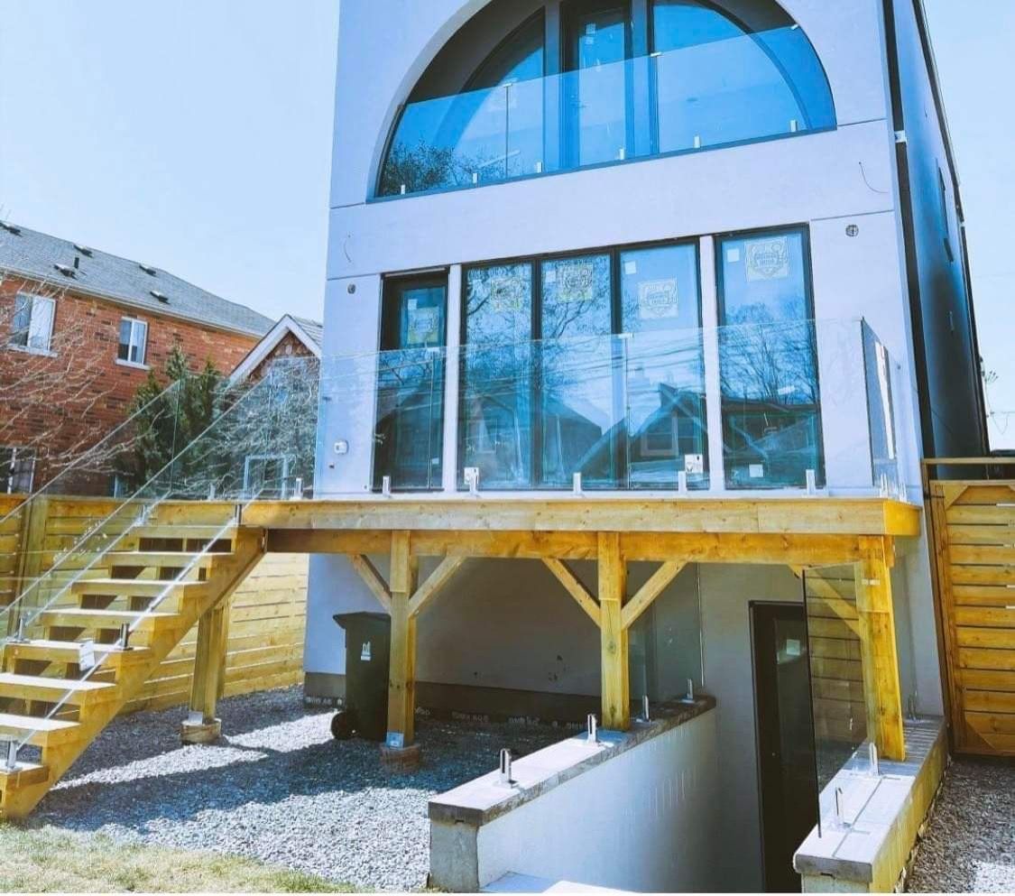 A white house with a wooden deck and stairs