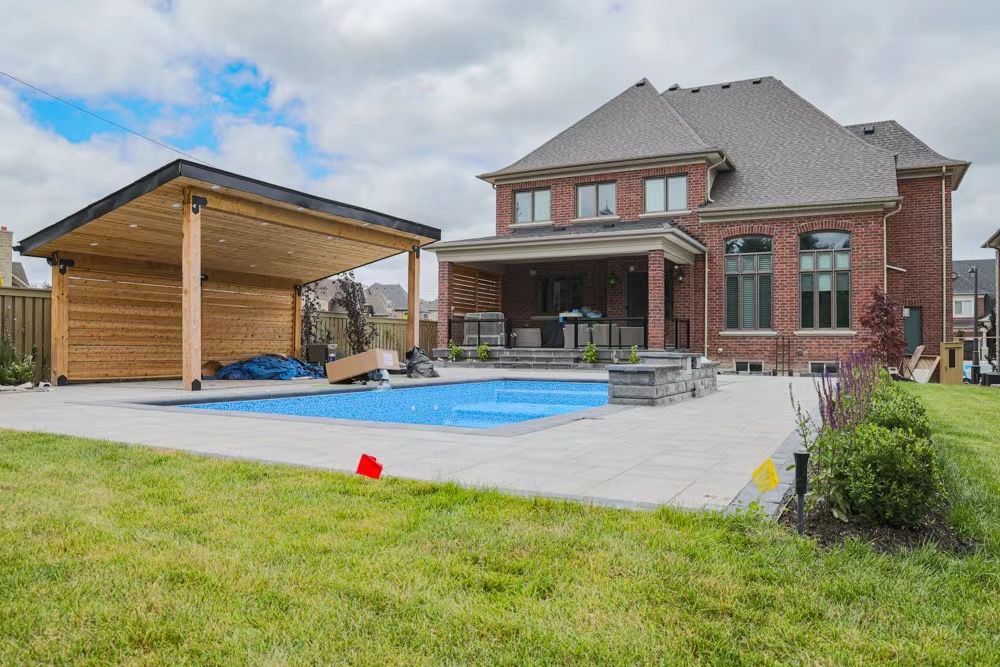 A large brick house with a large swimming pool in the backyard.