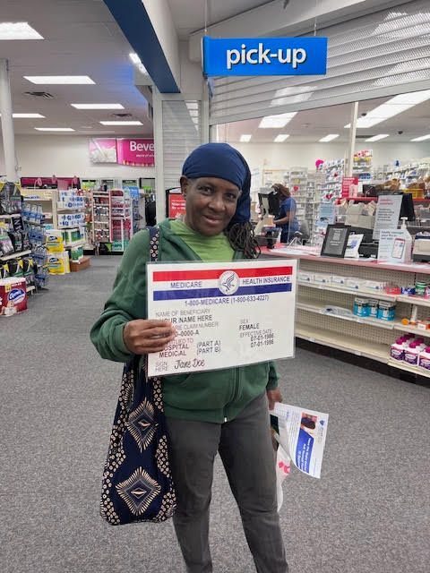 A woman is holding a sign in a pharmacy.