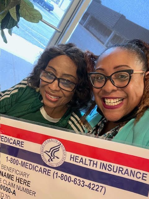 Two women are posing for a picture with a health insurance card.