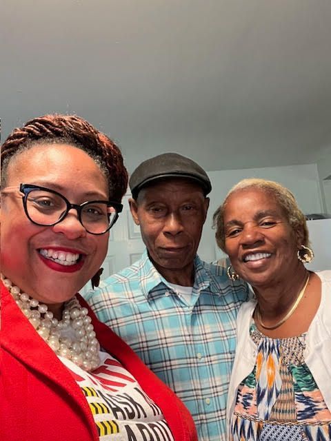 A man and two women are posing for a picture together.
