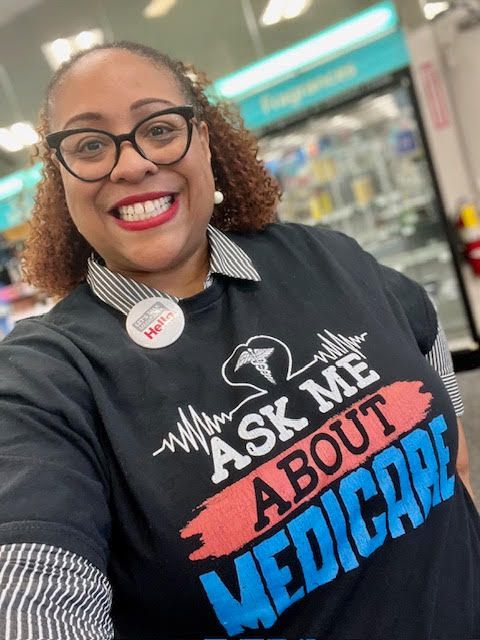 A woman is wearing a t-shirt that says `` ask me about medicare ''.