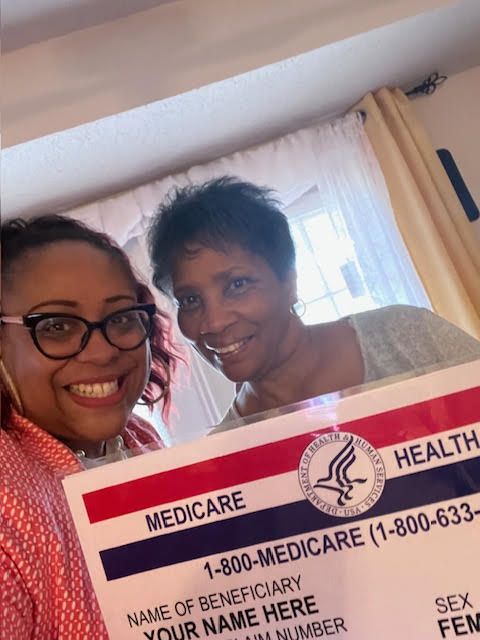 Two women are standing next to each other holding a medicare card.