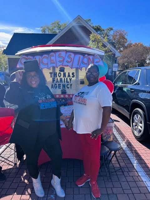 Two women are posing for a picture and one of them is wearing a shirt that says ask me about medicine.