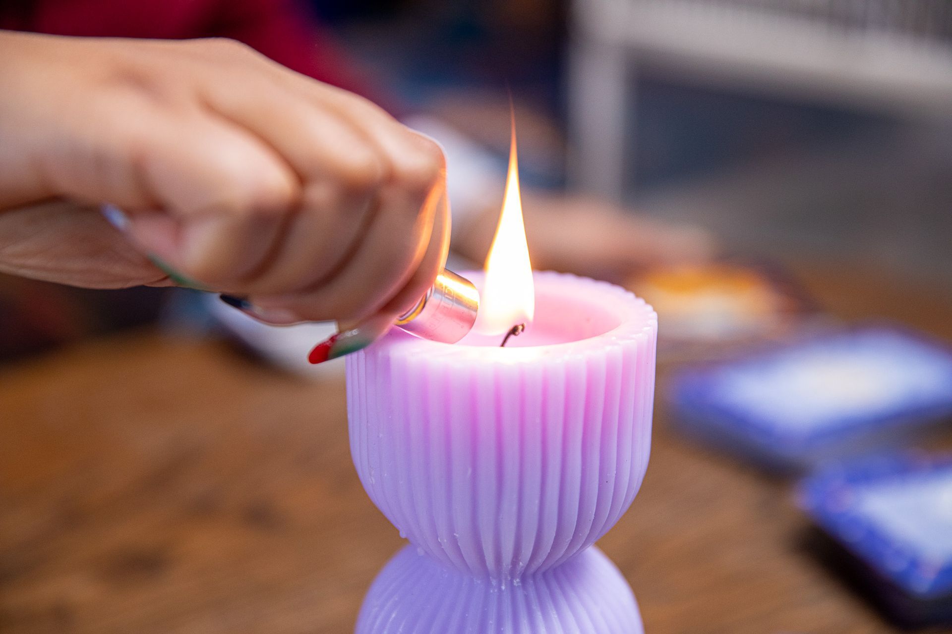 A person is lighting a purple candle with a fork.