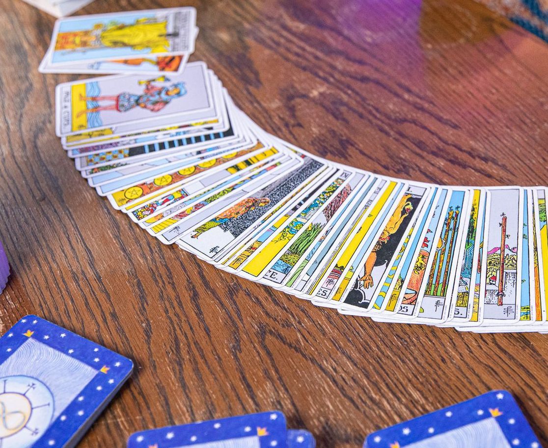 Tarot cards are on a wooden table.