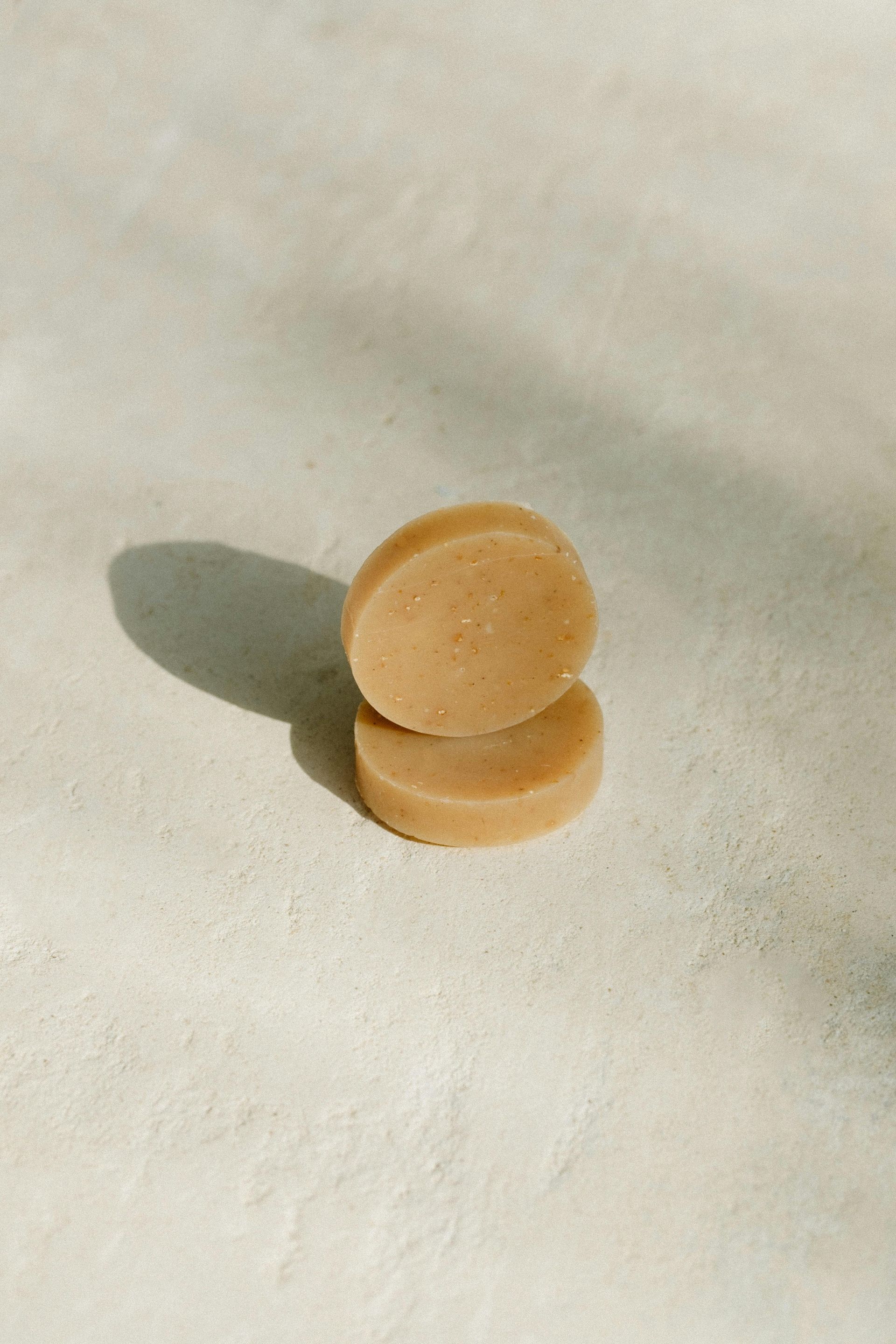 Two pieces of soap are stacked on top of each other on a table.