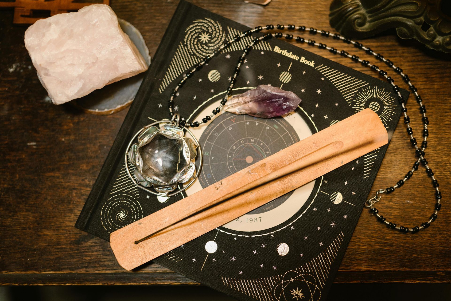 A wooden incense burner is sitting on top of a book on a table.