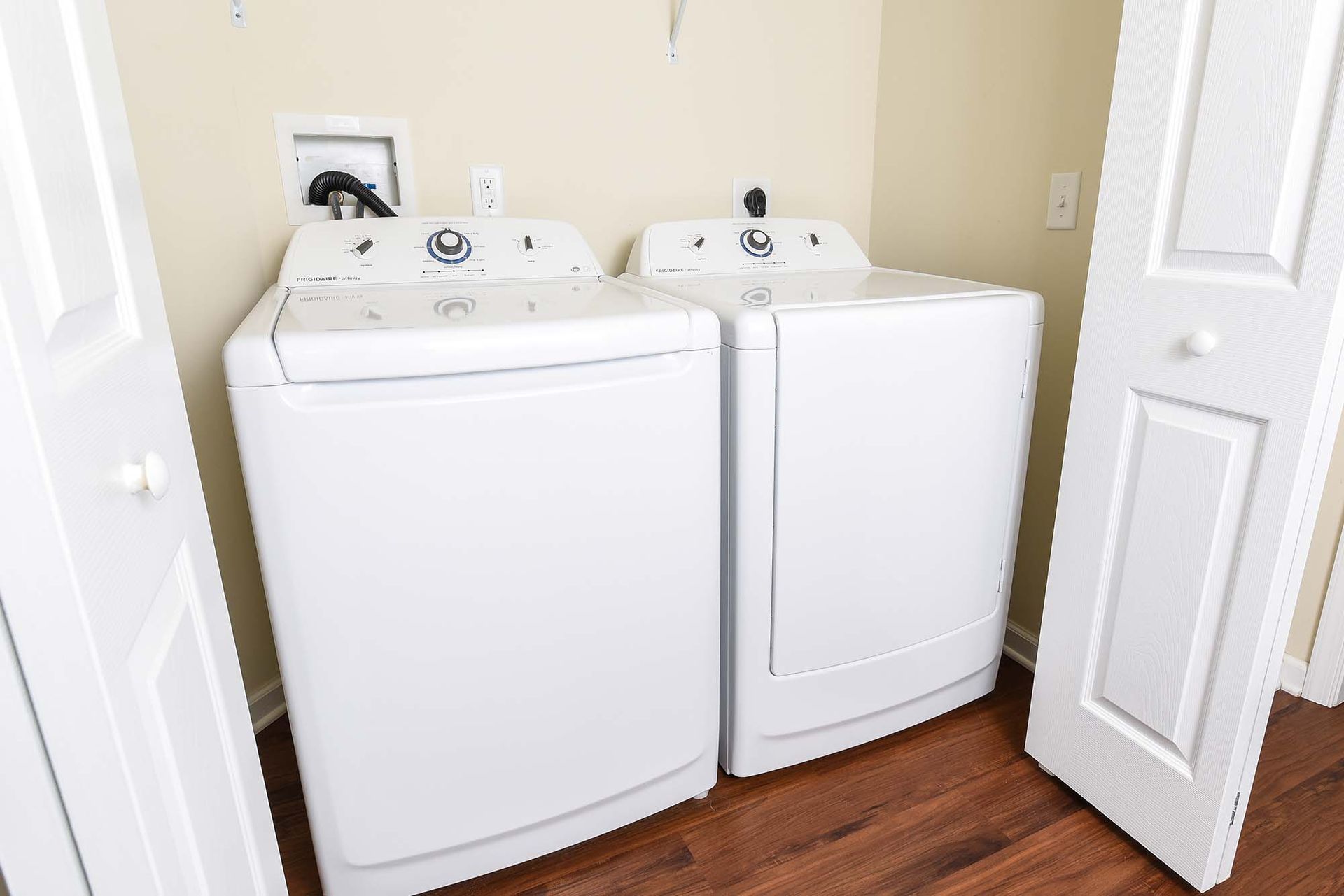 White washer and dryer in a compact laundry closet.