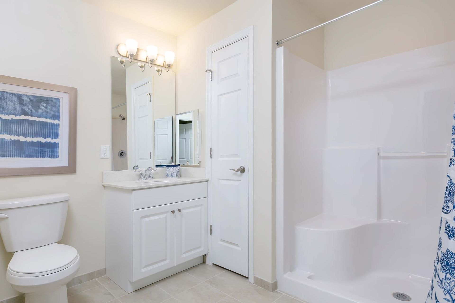 Bathroom with white vanity, mirror, toilet, and shower-tub combo.