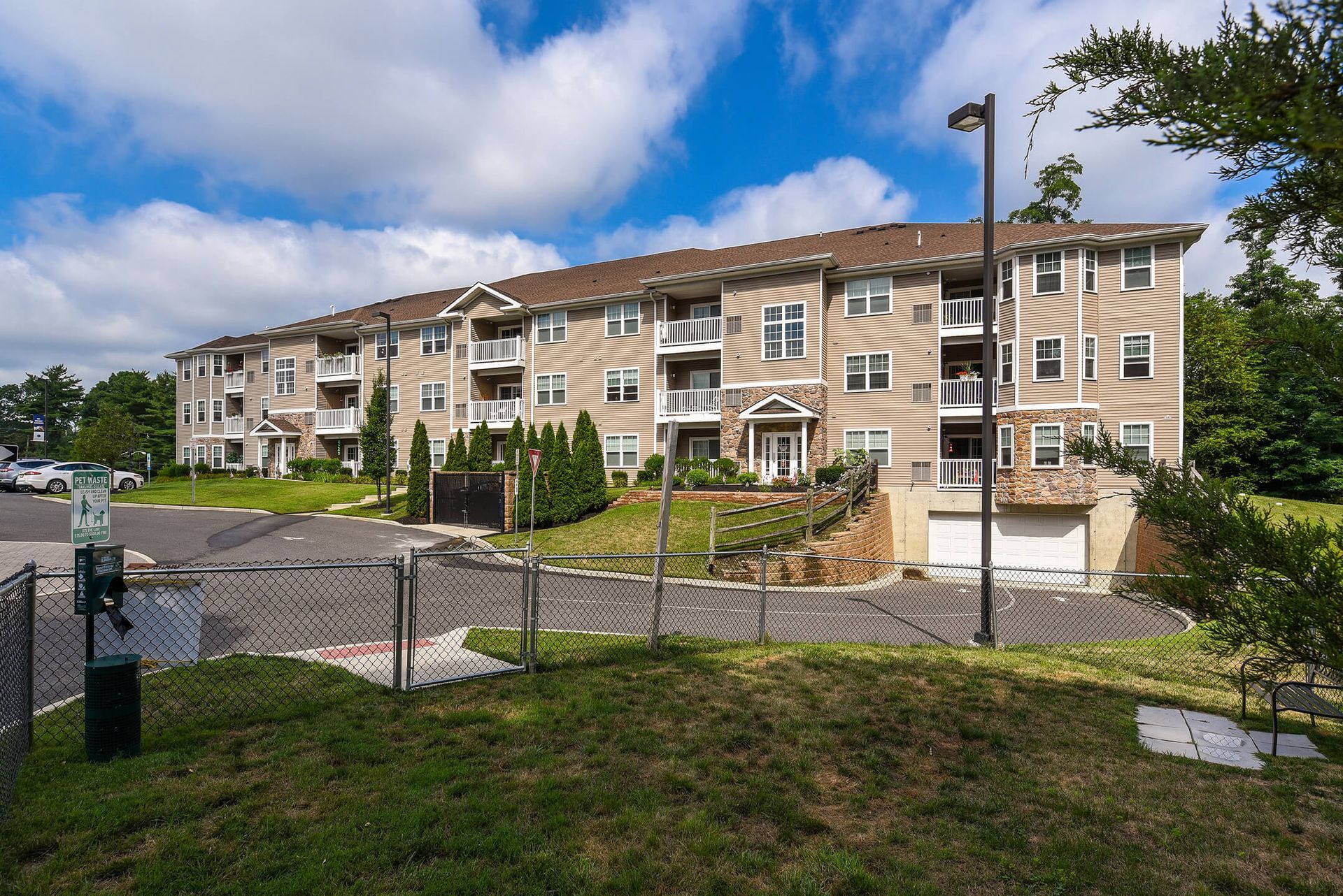 Exterior view of a beige multi-building apartment community with balconies and landscaped grounds.