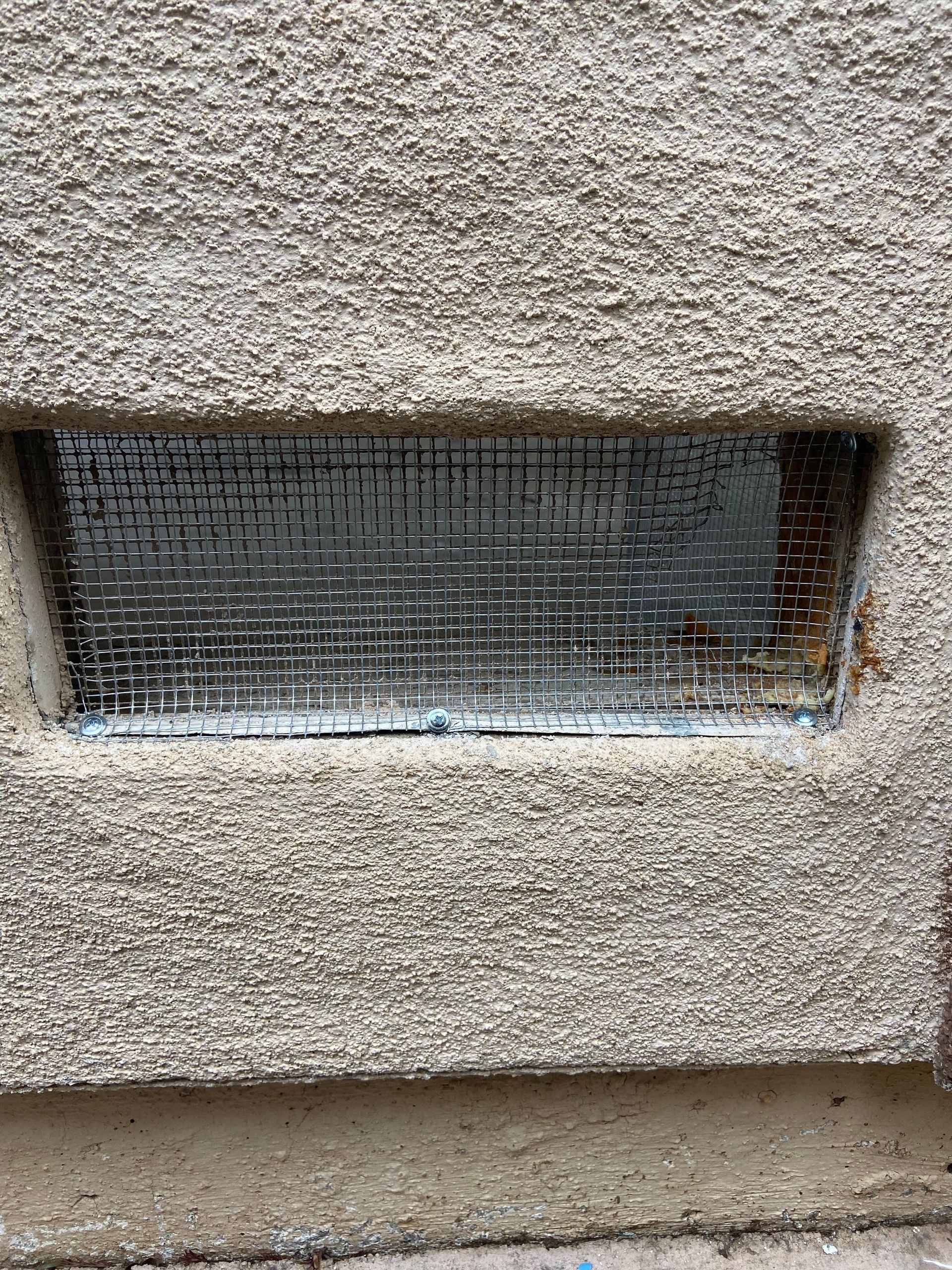 A close up of a window on a concrete wall.