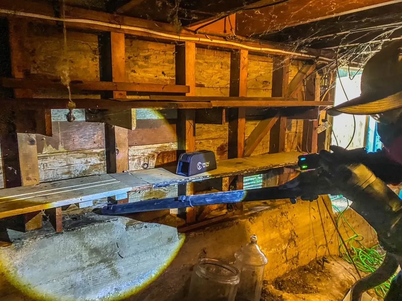 A person is taking a picture of a shed with a camera.