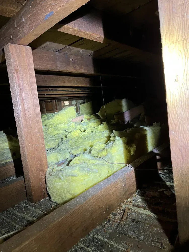 There is a lot of insulation in the attic of a house.