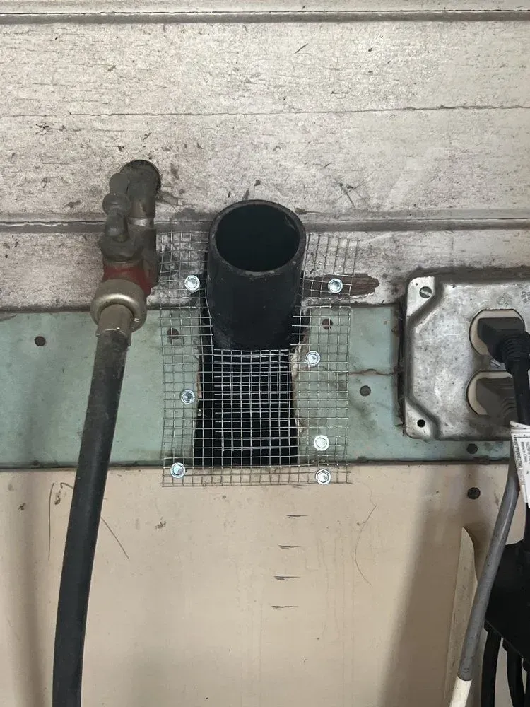 There is a hole in the wall with a hose coming out of it.