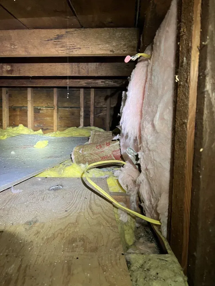 There is a hose hanging from the wall in the attic.