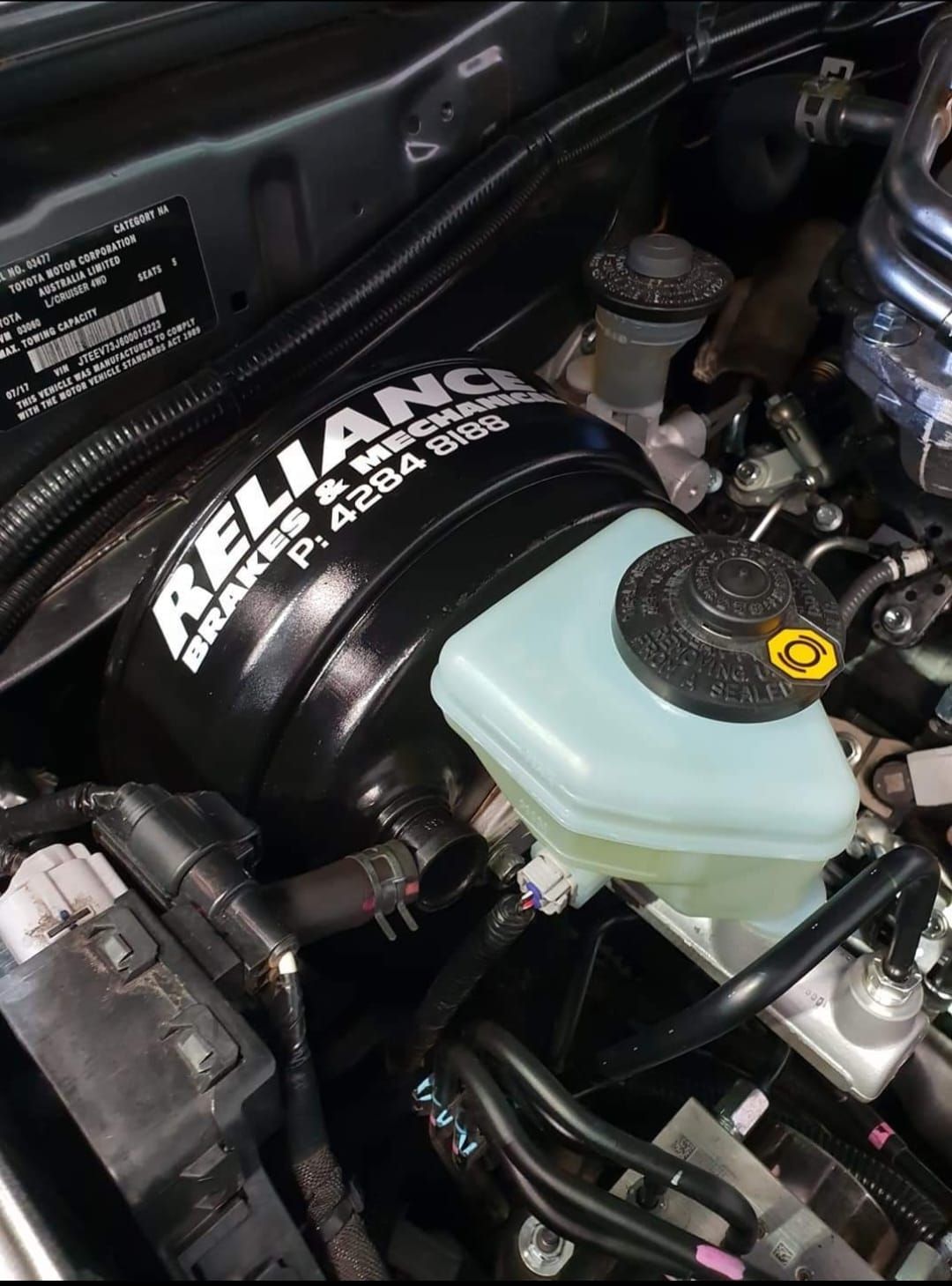 A close up of a car engine with a brake master cylinder