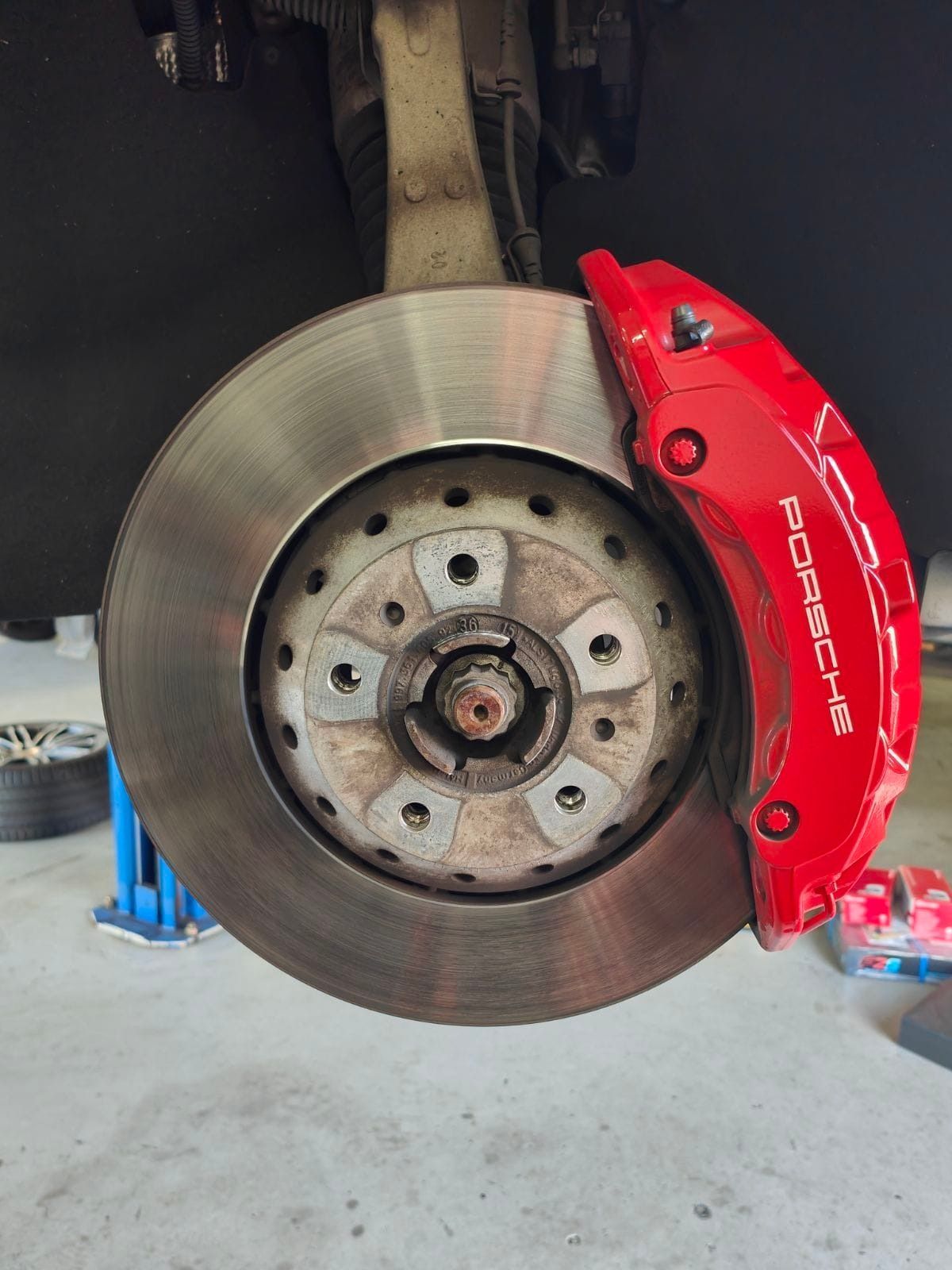A close up of a red porsche brake caliper on a car