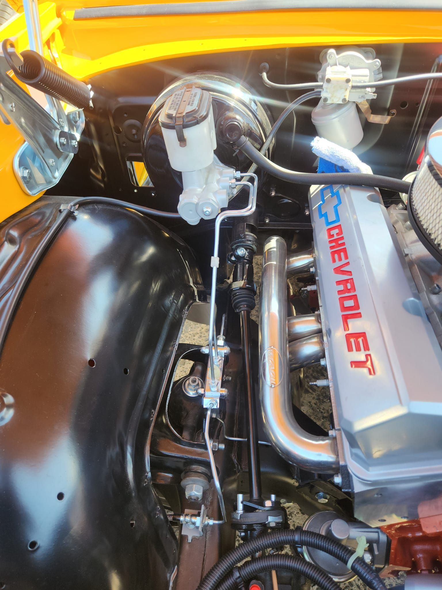 A close up of a chevrolet engine in a yellow car