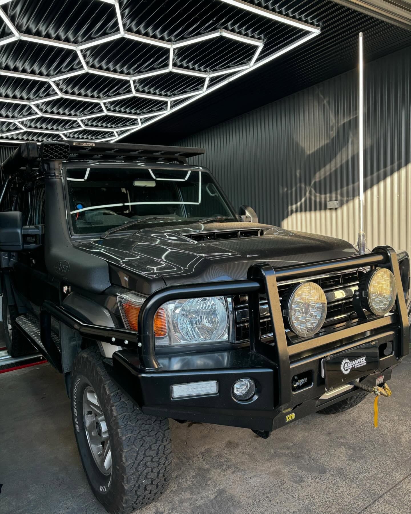 A black toyota land cruiser is parked in a garage.