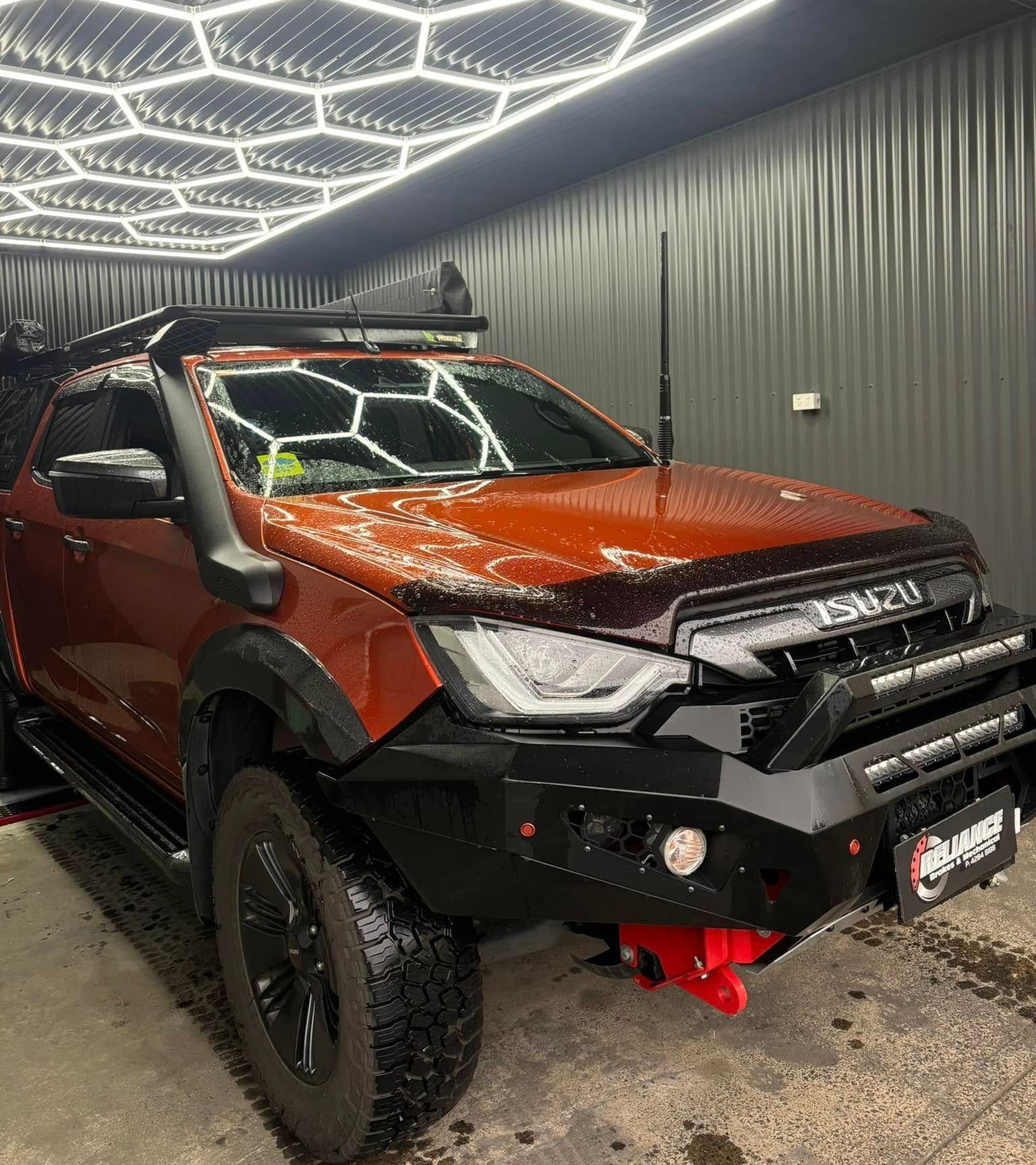 A white truck is parked in front of a building that says reliance brakes.