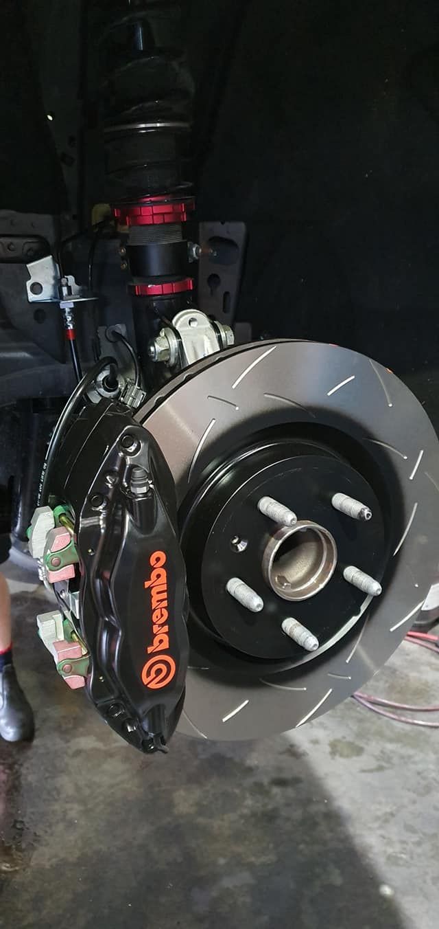 A close up of a brembo brake caliper on a car.