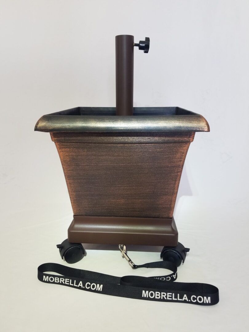 A picture of a planter with a umbrella holder attached to it.