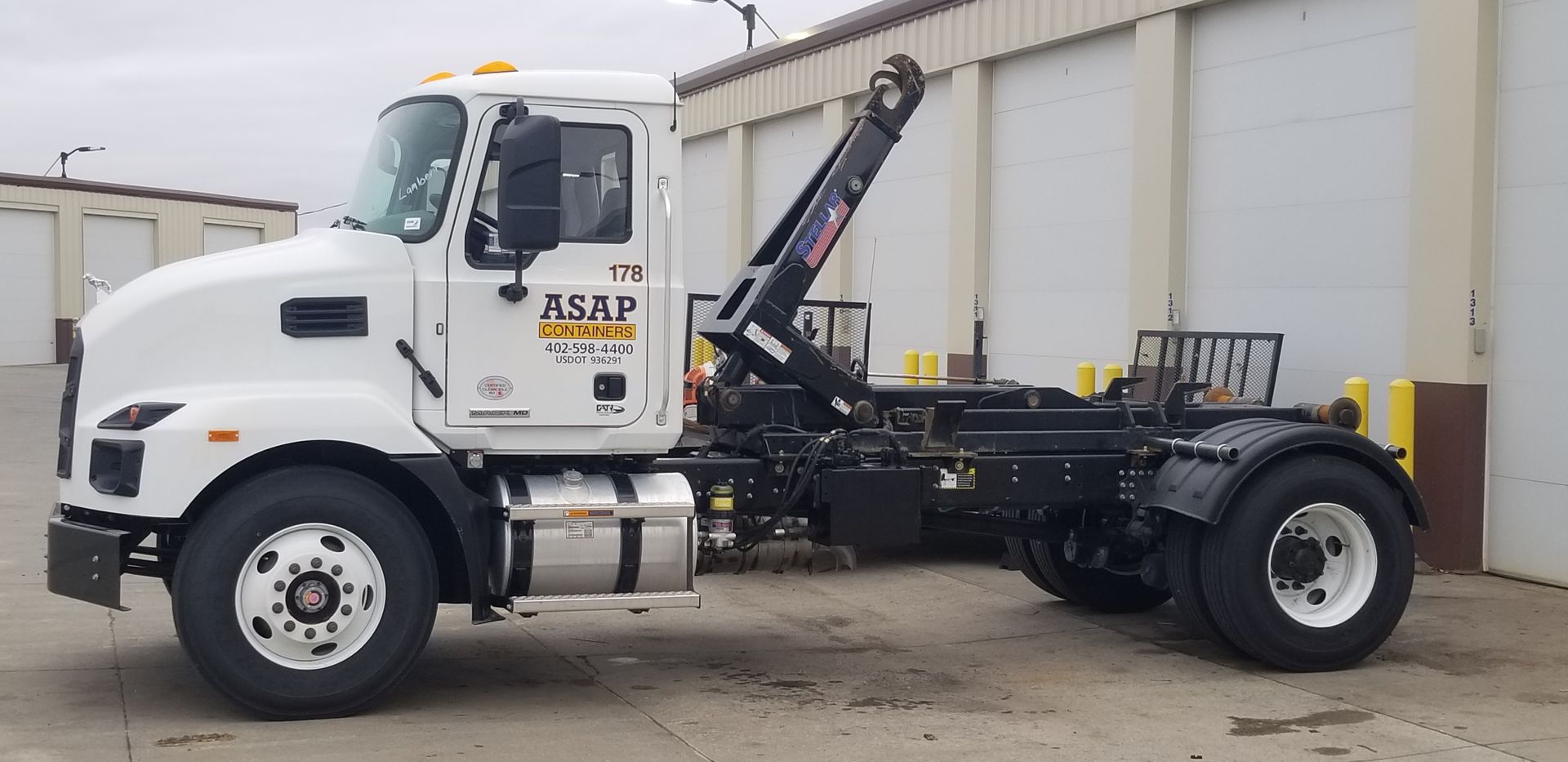 A large blue dumpster filled with various types of construction debris and waste materials.