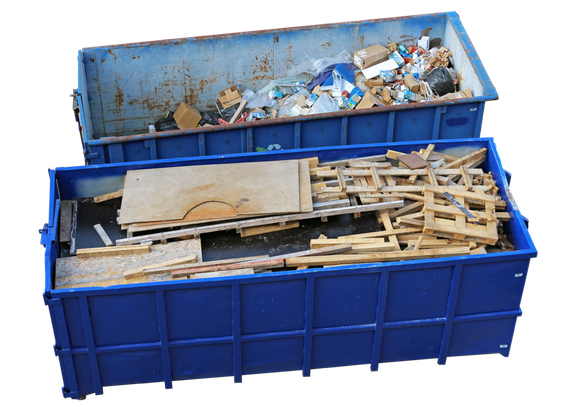 Two large blue dumpsters filled with assorted construction debris and waste materials, stacked at a construction site. 