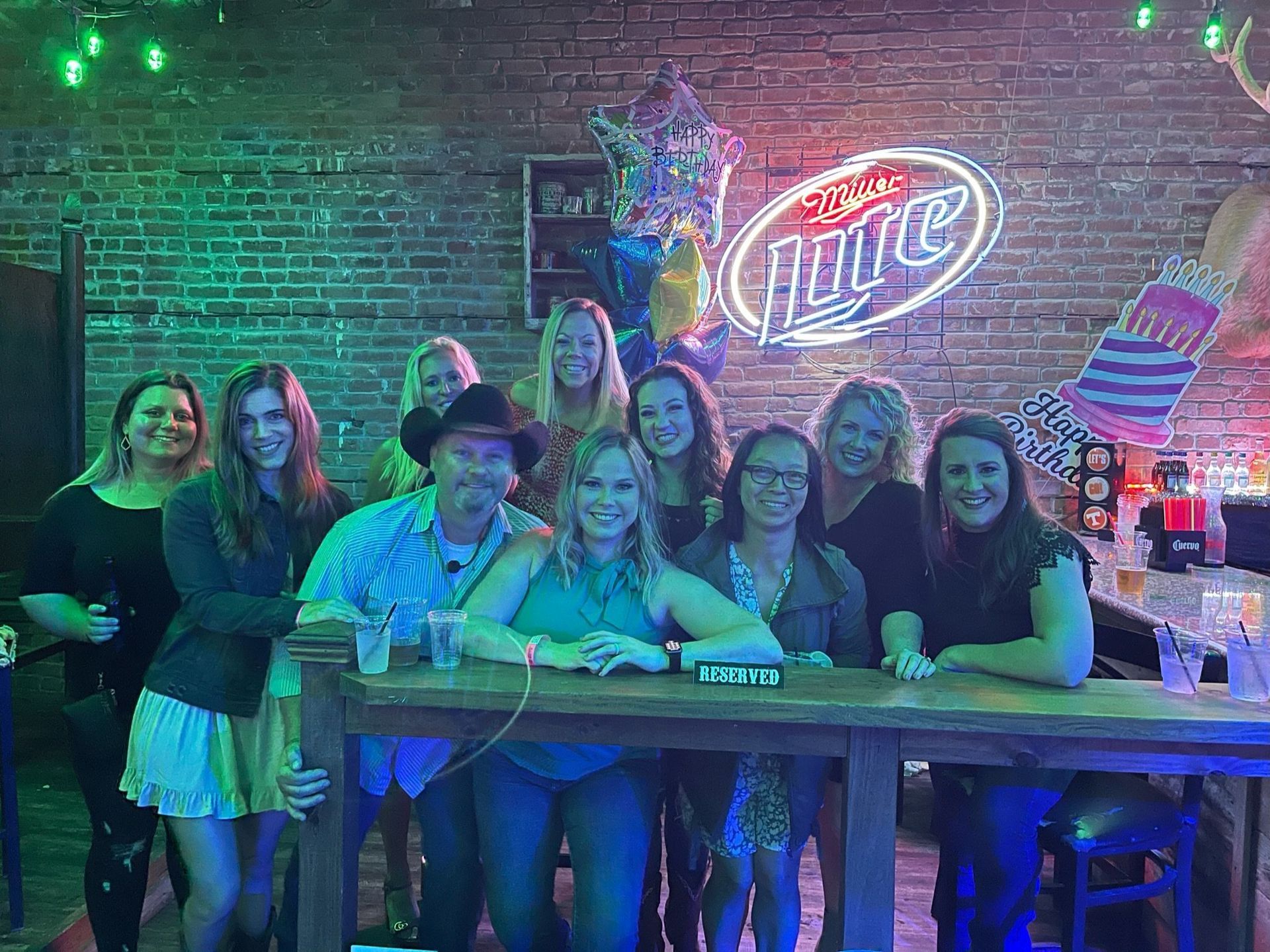 Group Posing in Front of a Sign — Galveston, TX — Buckshot Saloon
