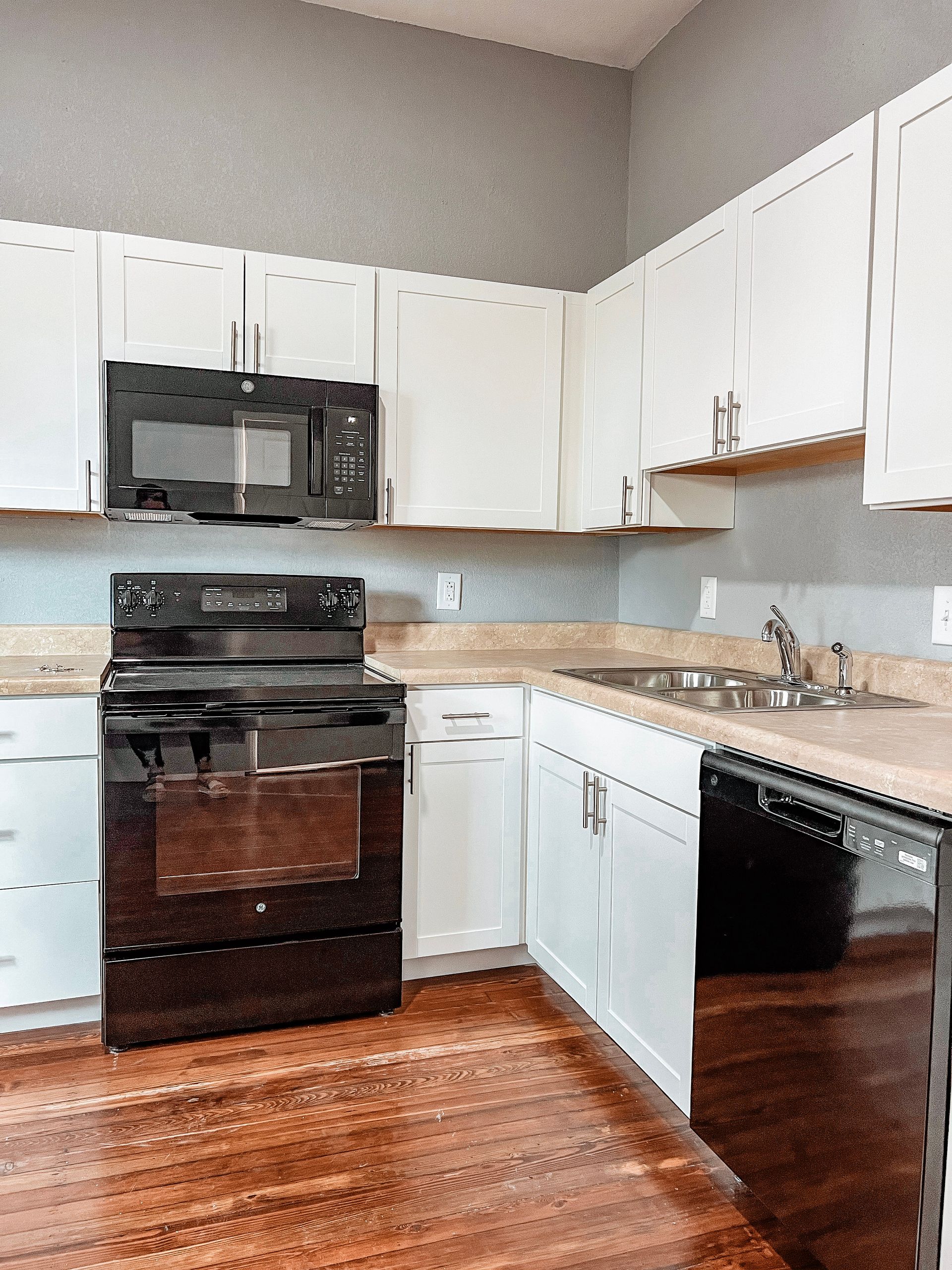 A kitchen with white cabinets and a black stove top oven