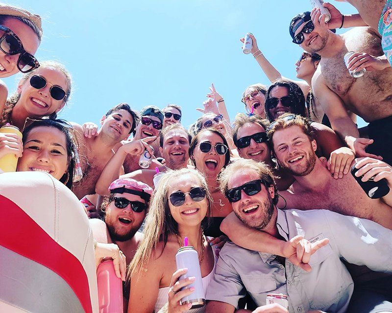 coworkers posing together on a lake travis party boat during their corporate event
