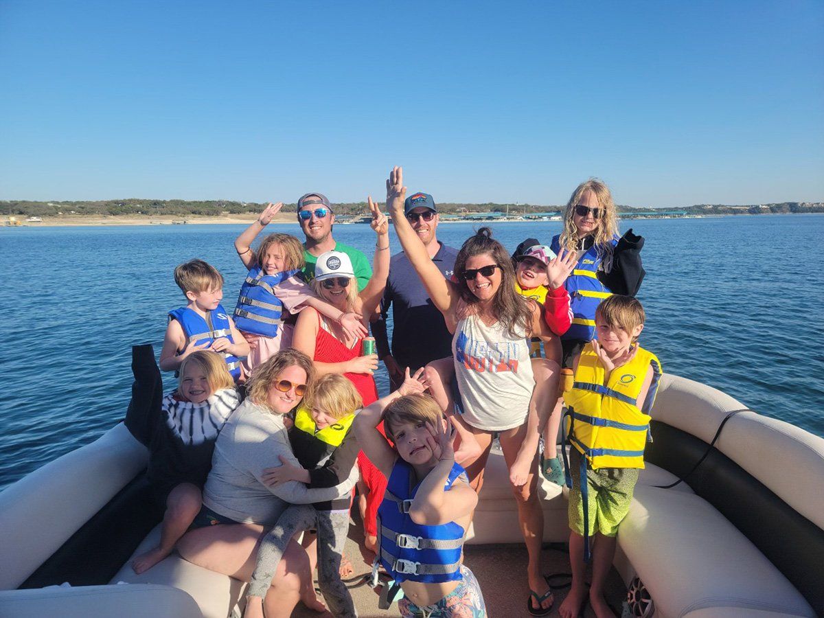 group photo of a family having their kids birthday party on a party boat on lake travis
