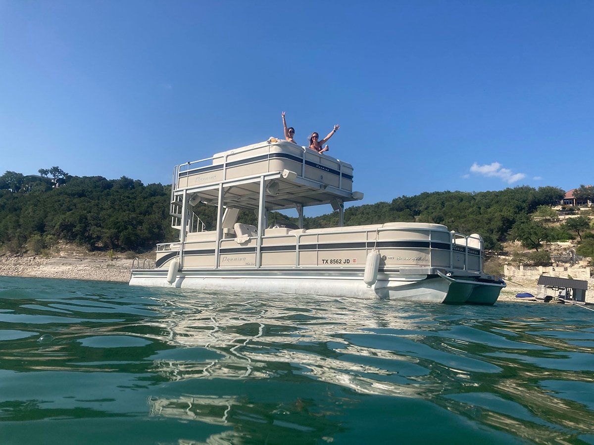 two girls on the top level of a party boat on Lake Travis