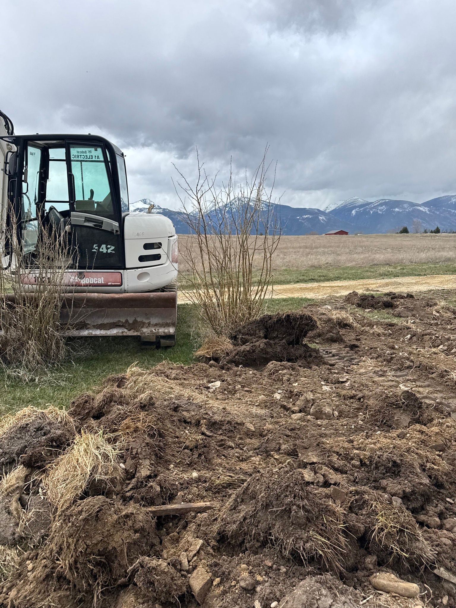 A bulldozer is sitting in the middle of a dirt field.