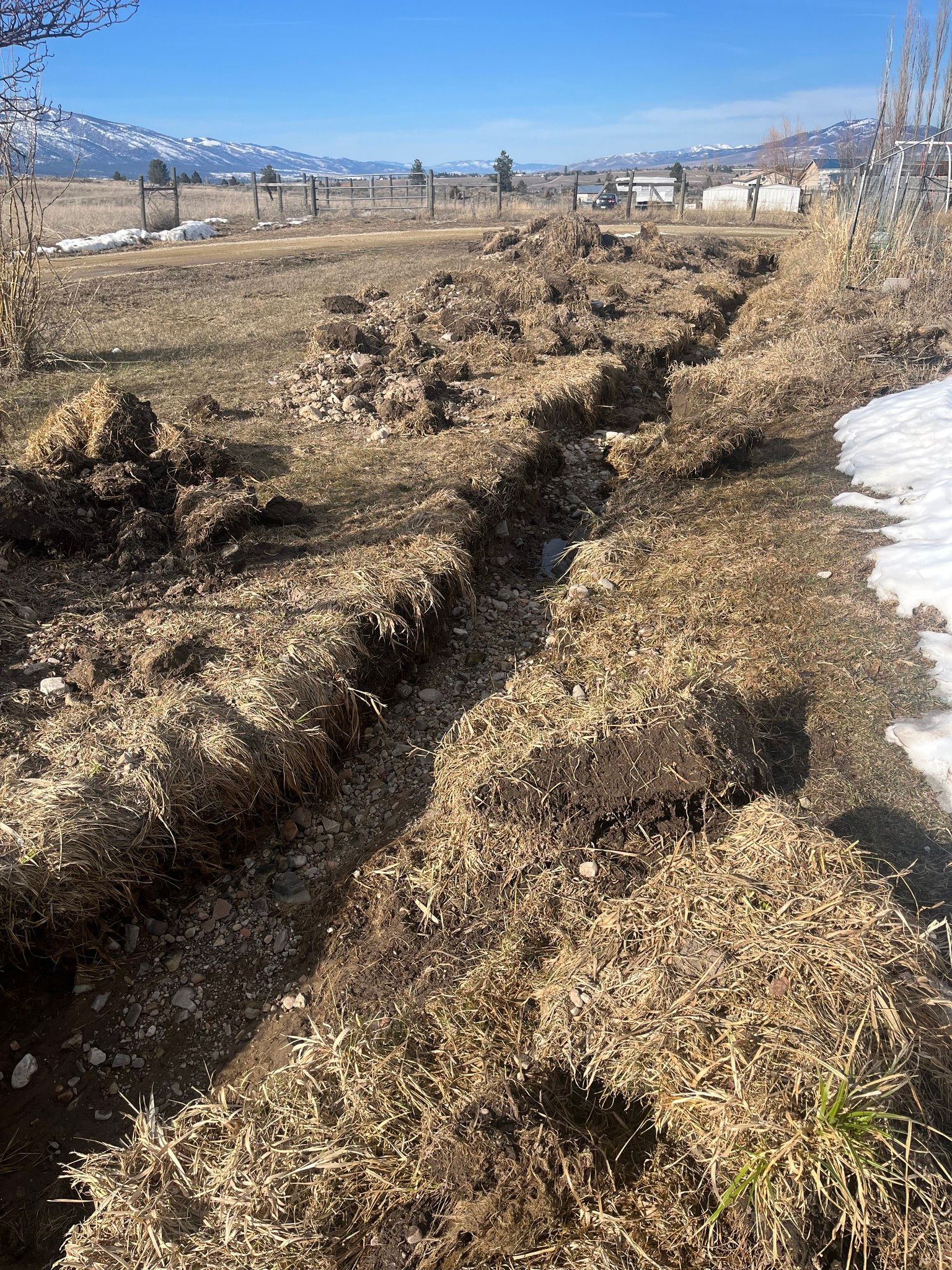 A pile of hay is laying on the ground in a field.