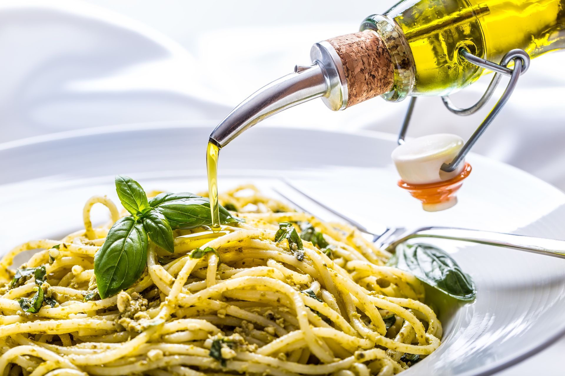 spaghetti al pesto conditi con olio di oliva a filo