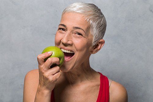 woman with short hair eating apple