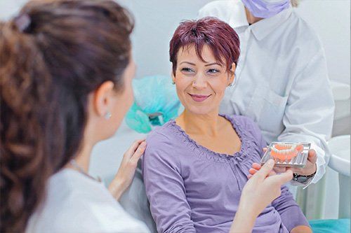dentist showing patient dentures