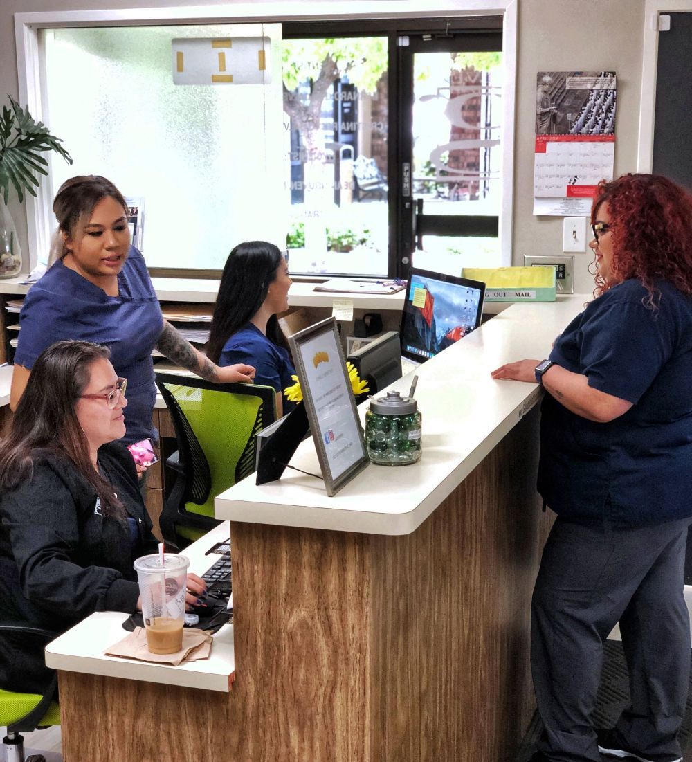 A group of women are standing around a counter in an office