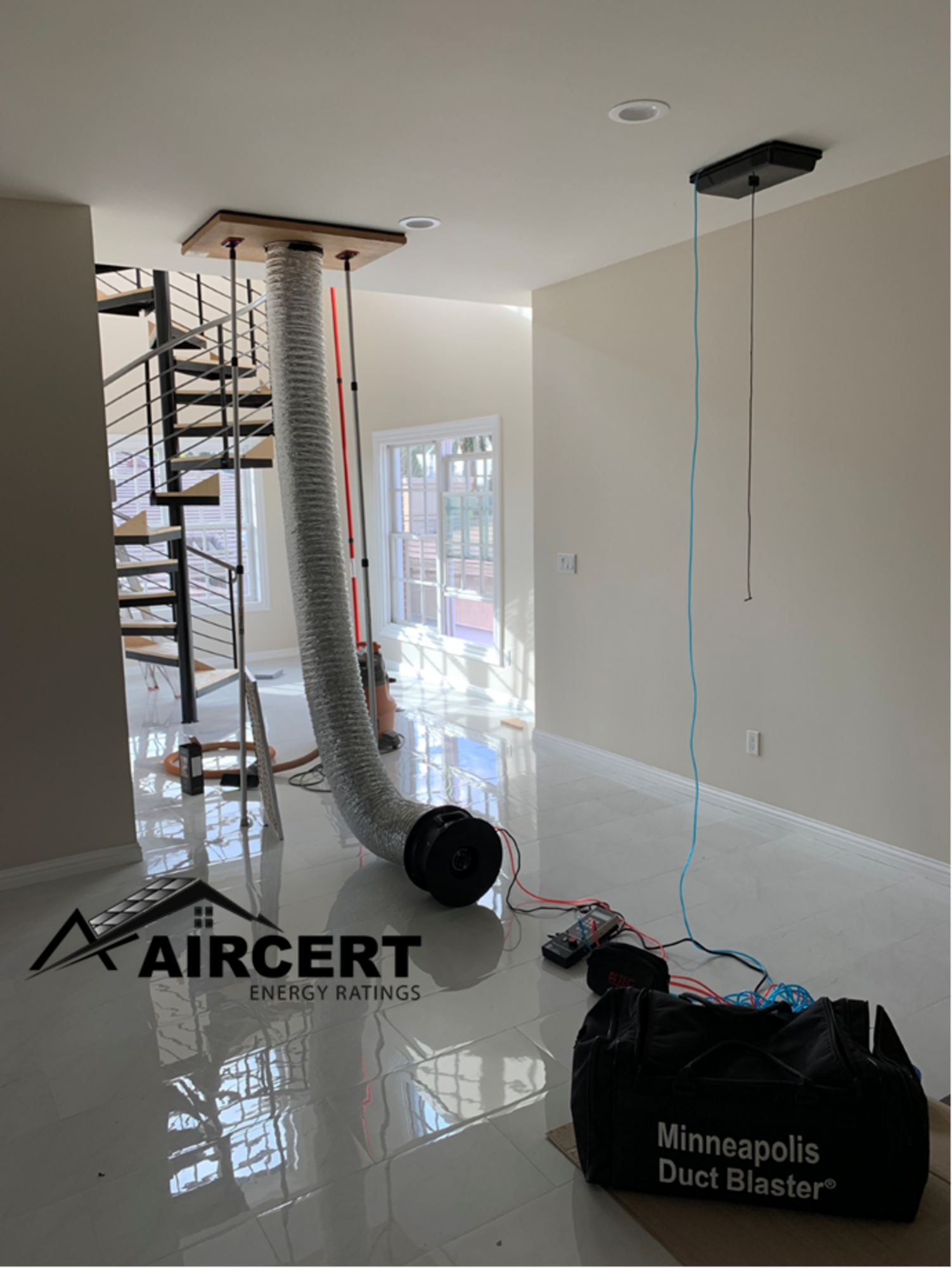 A room with a spiral staircase and a bag on the floor.