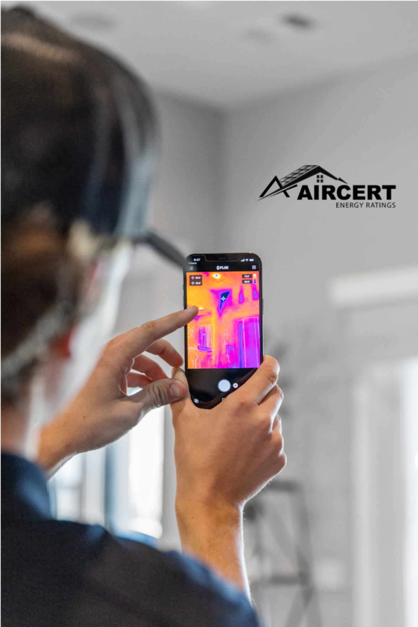 A man is taking a picture of a building with a cell phone.