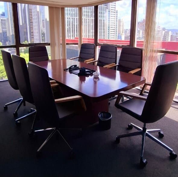 Uma sala de conferências com uma mesa grande e cadeiras