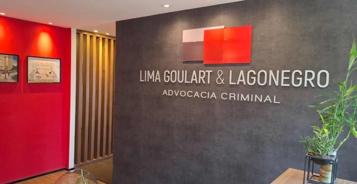 Uma sala com uma placa na parede que diz lima goulart & lagonegro advocacia criminal.