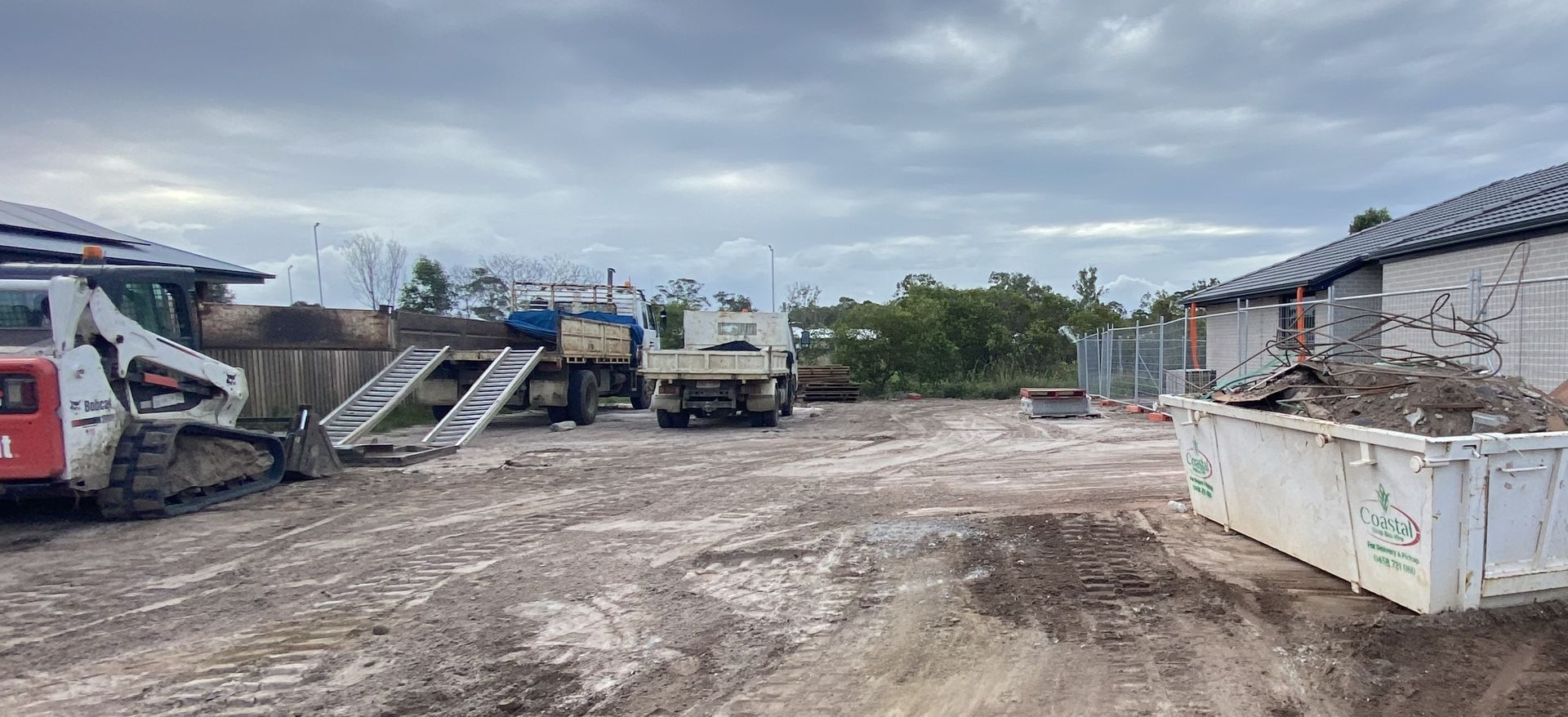 Construction Site with a Skid Steer Loader, Trucks, and a Dumpster — Snell Earthworx In Craignish, QLD