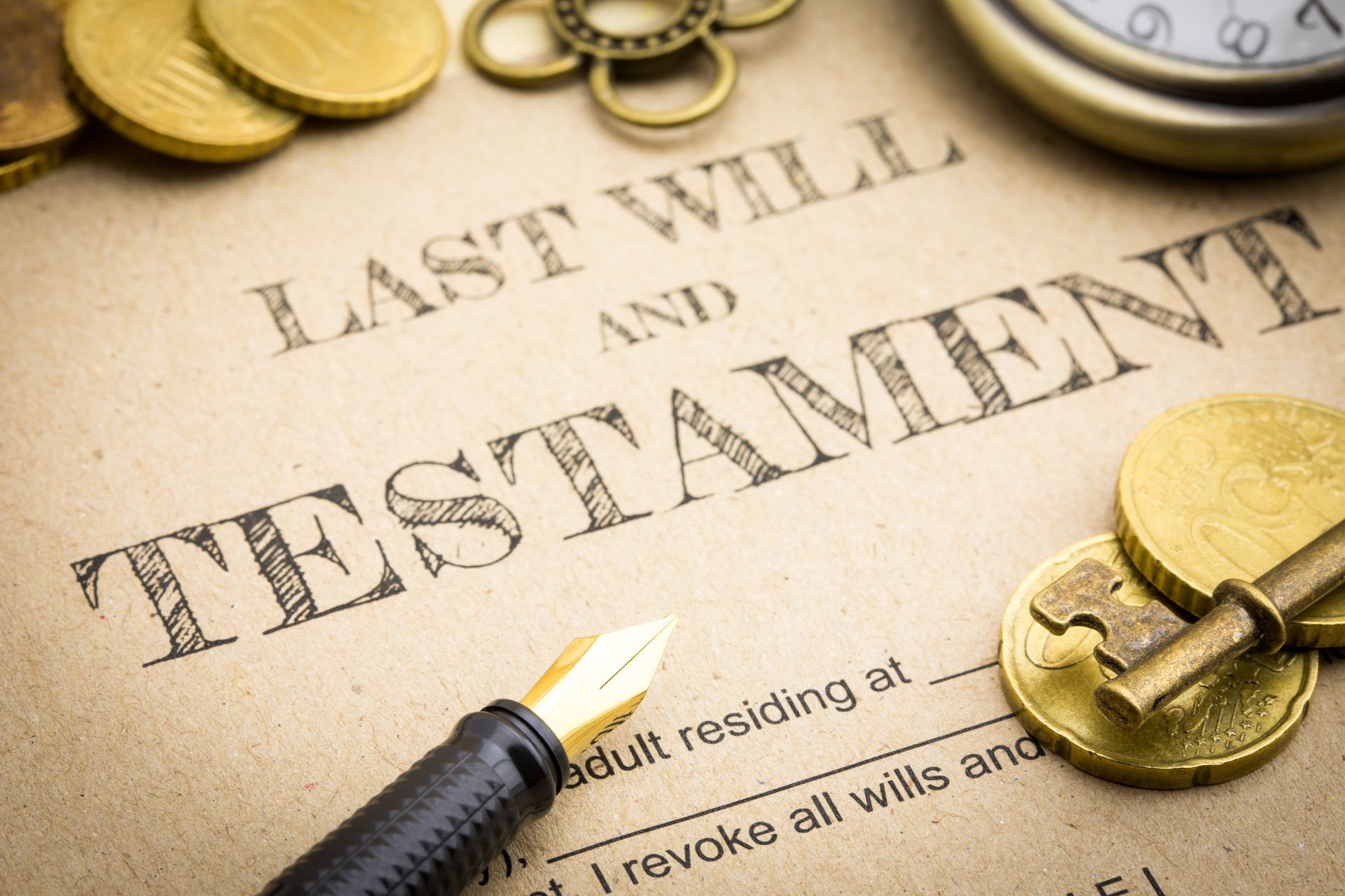 A document titled Last Will and Testament with a fountain pen, antique coins, a key, and a pocket watch.