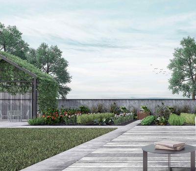 Lush garden with greenery, wooden pathway, and a table with books; overcast sky.