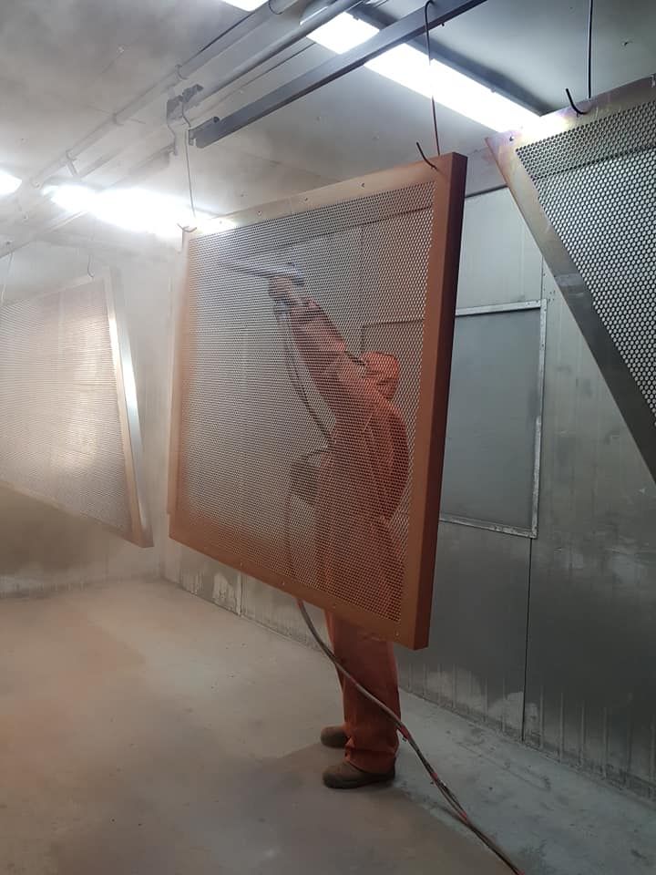 A Man Is Holding A Large Piece Of Wood — Border Security Doors & Powder Coating in Wodonga, VIC