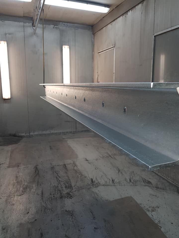 A Large Metal Beam Is Hanging From The Ceiling — Border Security Doors & Powder Coating in Wodonga, VIC